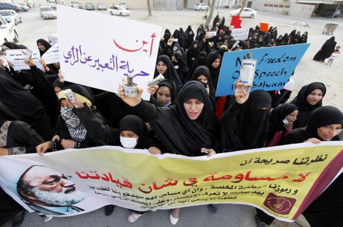 Protesters holds tear-gas canisters as they participate in an anti-U.S. protest held to condemn the sales of arms to Bahrain, in the village of Diraz west of Manama