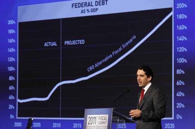 Michael Peterson of the Peter G. Peterson Foundation stands beside a chart showing the projected federal debt as a percentage of GDP at the 2011 Fiscal Summit on Solutions for America''s future in Washington