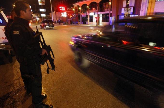 A police officer stands guard on a busy street in downtown Ciudad Juarez