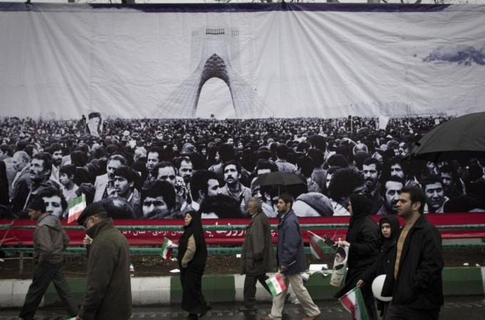 Iranian demonstrators walk past a pictur