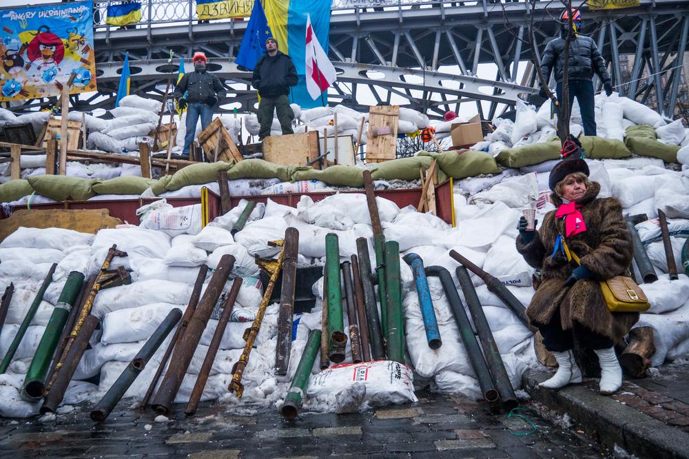 <p>Five volunteers guard the new barricade, under an "Angry Ukrainians" billboard.</p>