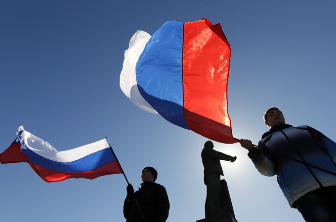 People hold Russian flags as they celebrate the results of the referendum on Crimea's status at the central square [EPA]