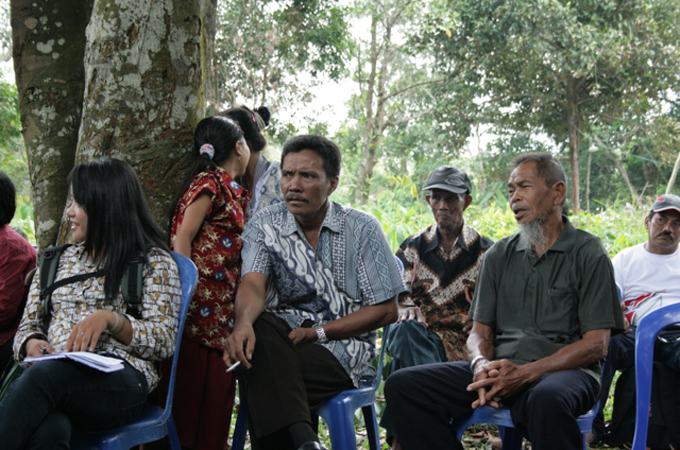 Ethnic Dayak villagers discuss encroachment by palm oil companies on their land [Dana MacLean/Al Jazeera]