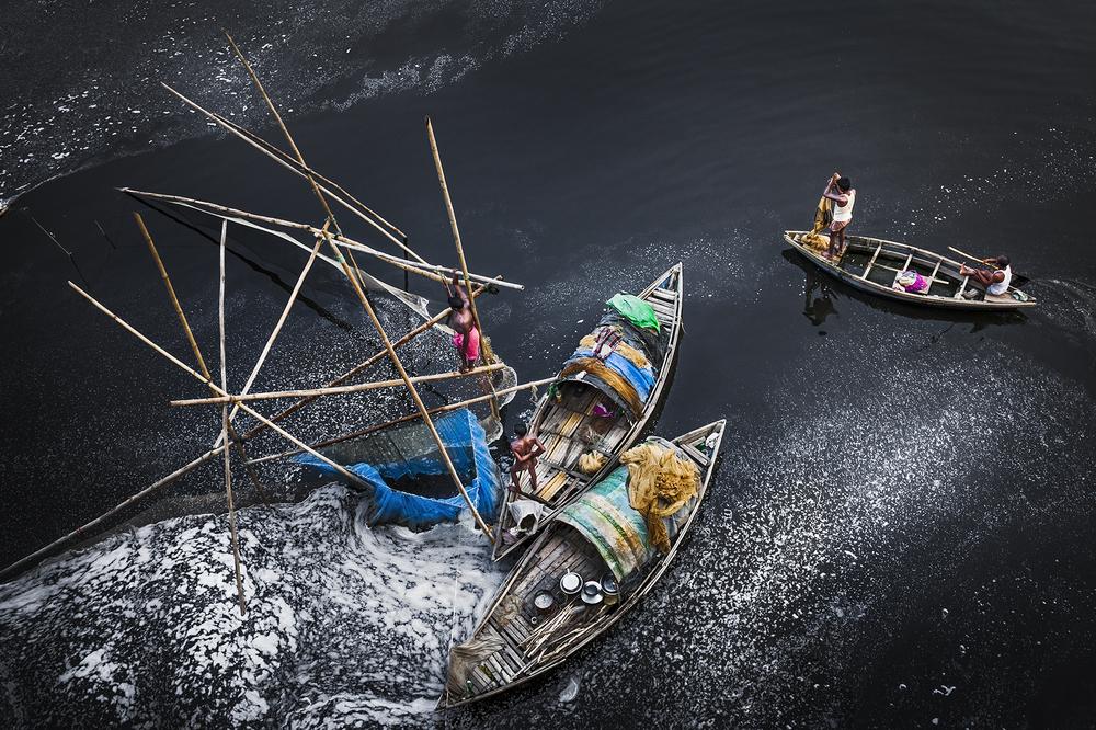 <p>Fishermen catch fish in the black poisonous waters of the Yamuna river at Okhla Barrage in south Delhi.</p>