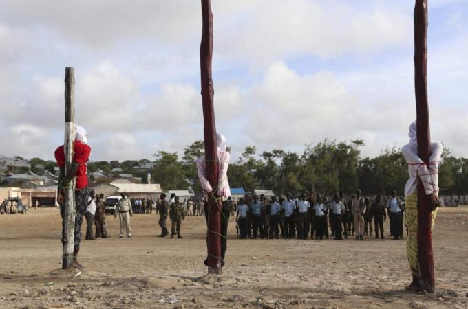 Three men found guilty by a Somali military court of killing civilians and masterminding a recent attack on the Presidential Palace were tied to poles shortly before they were executed by a firing squ