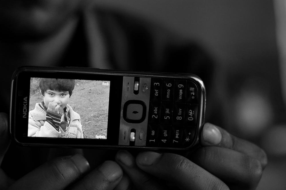 <p>A family member shows a photograph of Simran Riyaz who was killed while playing with littered shell outside her home. Simran(***)s five-year-old brother Fayaz Riyaz, who was playing with her, lost both limbs.</p>