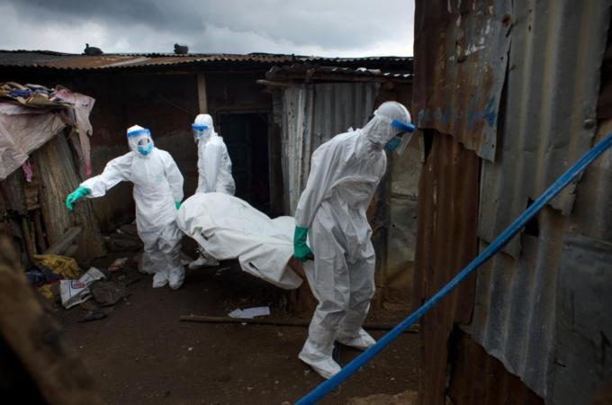Members of a burial team remove the body of a 30-year-old man in Freetown, Sierra Leone [Getty Images]
