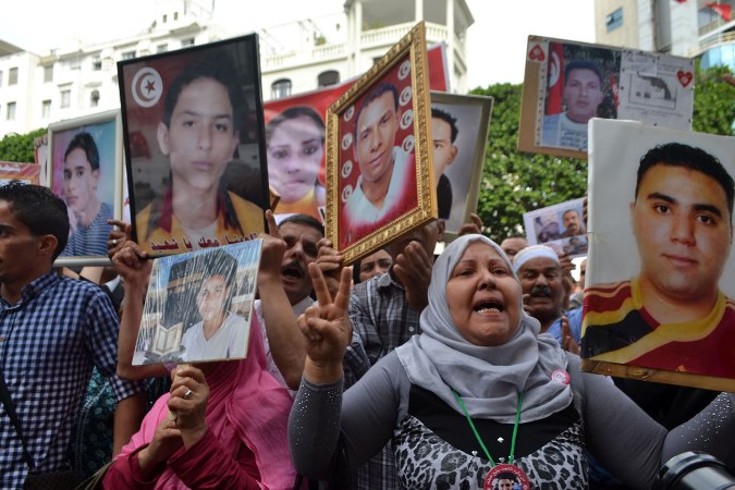Photos of the martyrs of the revolution were held up during the march [Adeline Bailleul/Al Jazeera]