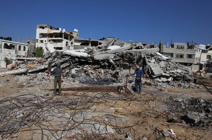 Residents salvage what they can from the wreckage, hammering bent metal back into shape [Hatem Omar/Al Jazeera]