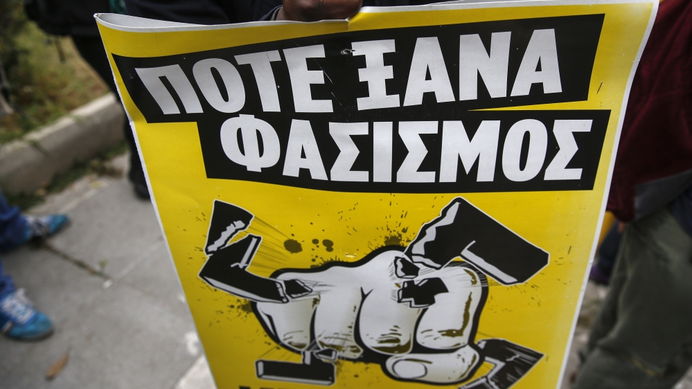 An anti-fascist protester shouts slogans and holds a banner that reads: "Never Again Fascism", during a rally in the Korydallos suburb, near Athens [AP]