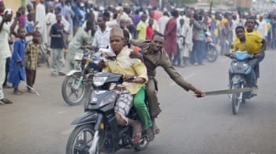 A supporter of Muhammadu Buhari riding on a motorcycle [AP] 