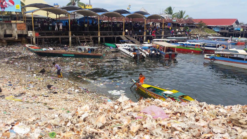 Undocumented children pick through rubbish at a jetty in Semporna [Chan Tau Chou/Al Jazeera]