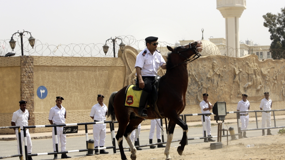 Egyptian policemen secure Egypt’s national police academy, where an Egyptian criminal court sentenced Morsi to 20 years in prison [AP]