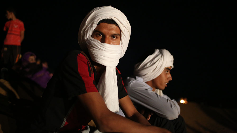 A young man watches the show at FiSahara - the world's remotest film festival [Hannah McNeish/Al Jazeera]