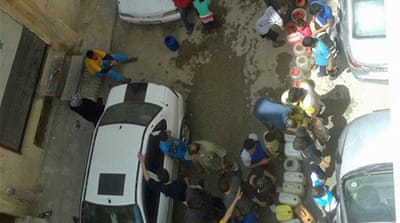 Lining up for water in Palmyra on Thursday [Nasser/Al Jazeera]