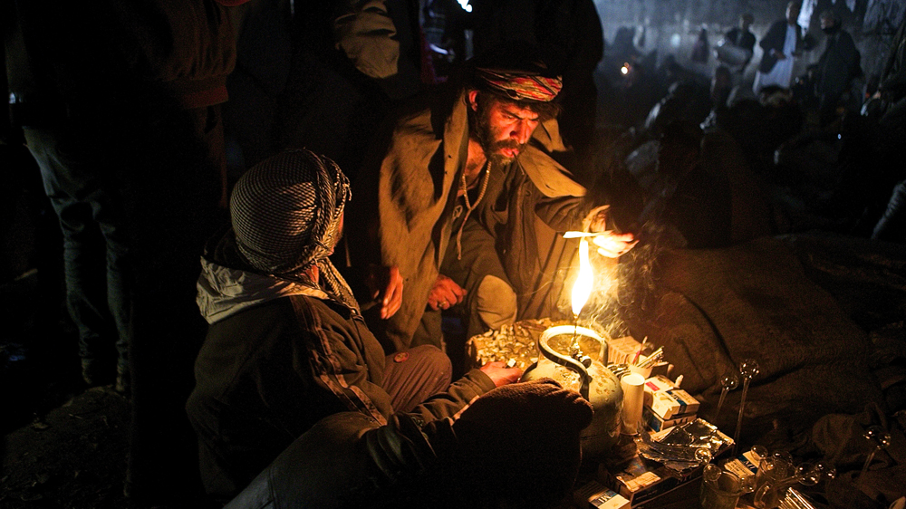 A group of Afghan men get high on heroin under a bridge in Kabul [Steve Chao/Al Jazeera]