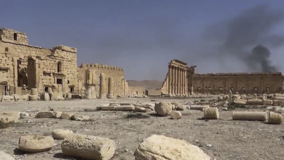Smoke rises behind archaeological ruins in Palmyra, Syria [AP]