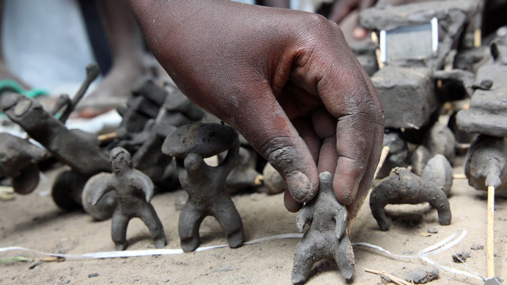 Children play with toys made of mud, some resembling tanks and machine-gun mounted vehicles [Simona Foltyn/Al Jazeera]