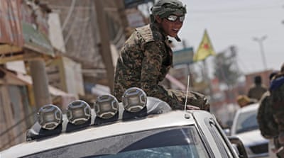 A member of YPG sits on a truck after leaving the Syrian town of Tal Abyad [EPA]