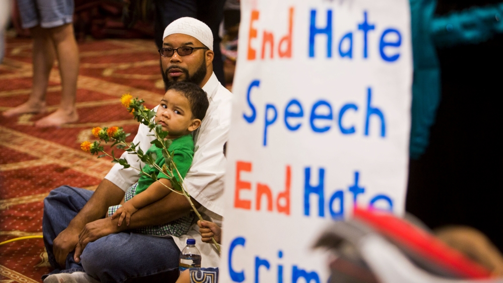 Attendees listen as speakers from different faiths speak at an interfaith rally titled 