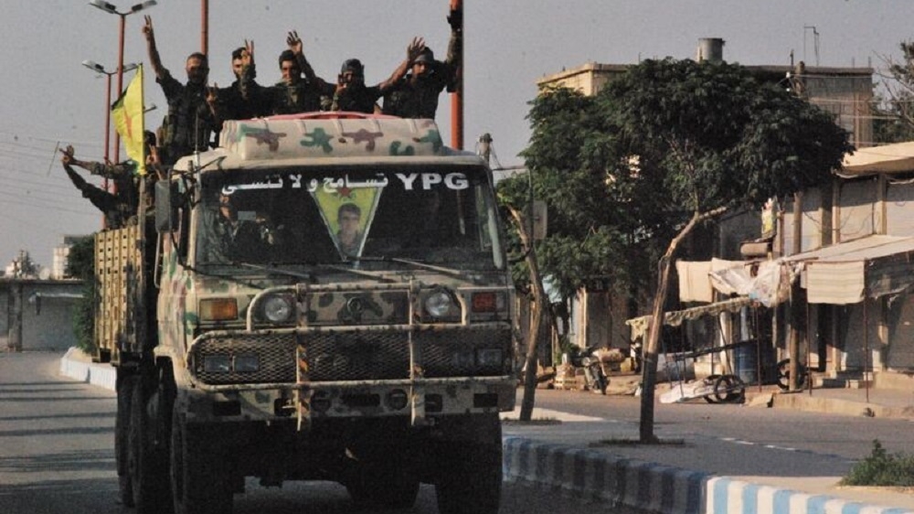 A group of Kurdish YPG fighters make the victory sign after capturing Tal Abyad from ISIL [Akhten Asaad/Al Jazeera]