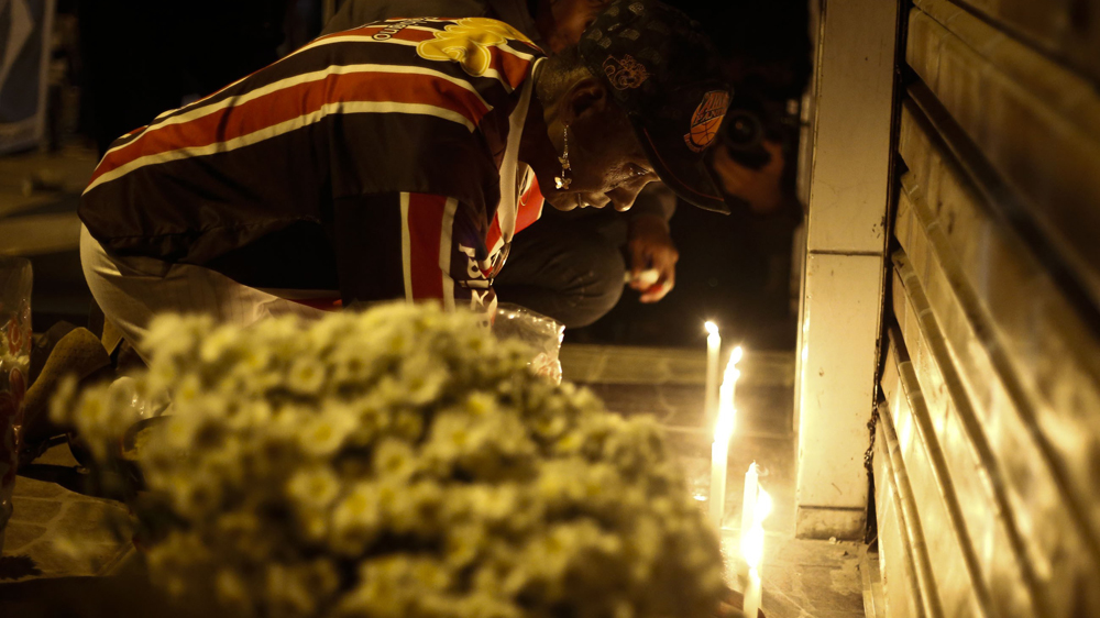 Maria de Paula joined other mourners in remembering victims at a street altar set up after the killings [Miguel Schincariol/AFP/Getty Images]