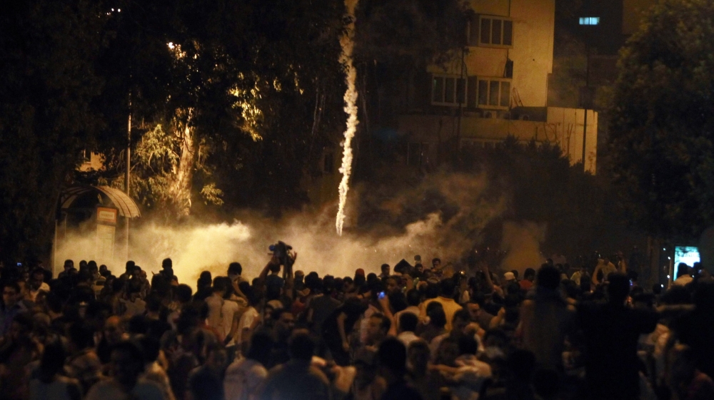 Protesters flee from tear gas during clashes front of the Israeli embassy in Cairo