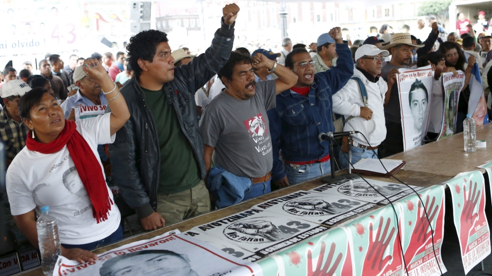 Relatives hold pictures of some of the 43 missing students of Ayotzinapa College Raul Isidro Burgos and shout during a news conference after a private meeting with Mexico''s President Enrique Pena Niet