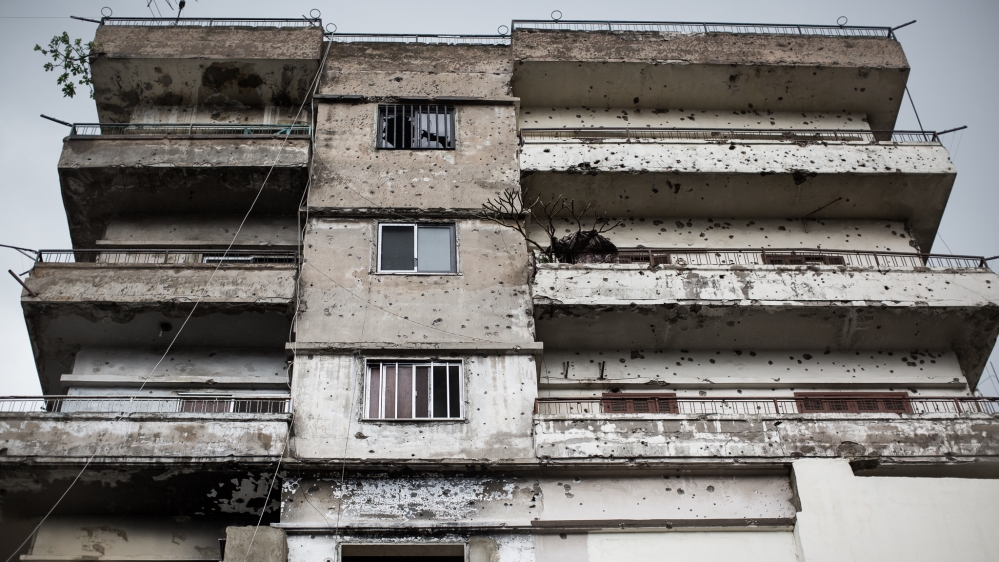 Homes on both sides of the dividing line between Bab al-Tabbaneh and Jabal Mohsen are littered with bullet holes [Dylan Collins/Al Jazeera]