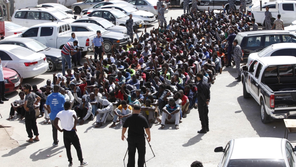 Illegal migrants sit at a temporary detention centre after they were detained by Libyan authorities in Tripoli