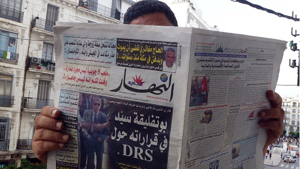 An Algerian man reads a local newspaper, En-Nahar, bearing a picture for the first time of former Algerian intelligence chief General Mohamed Mediene, better known as General Toufik, on the front cove