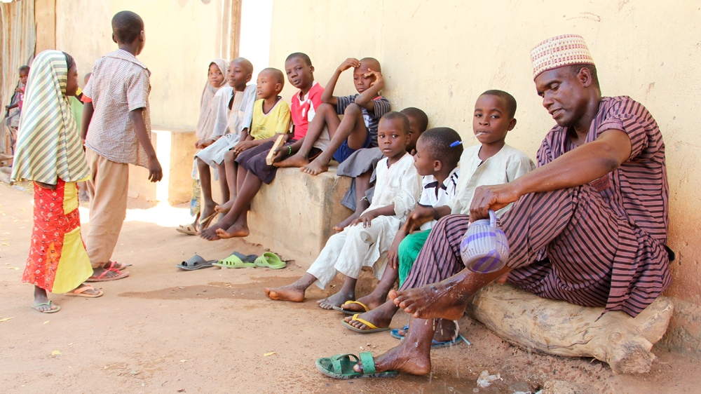 Ward head Idrisu Mohammed performs his ablutions before going into the mosque to pray. He says people have become more vigilant over the past few months [Femke van Zeijl/Al Jazeera] 