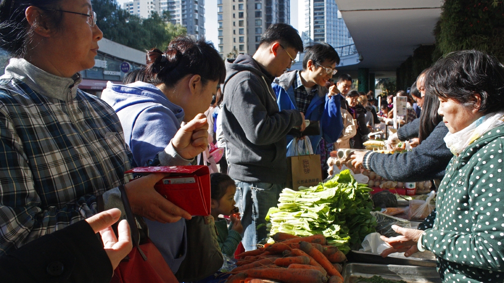 Located in the suburbs of Beijing, an otherwise quiet outdoor shopping centre is transformed into a makeshift organic market [Katrina Yu/Al Jazeera]