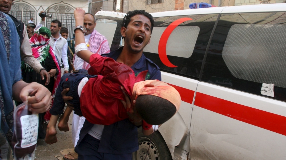 Man shouts as he carries a boy injured by a shell that landed in a residential area during fighting between Houthi militants and pro-government militants in Yemen''s southwestern city of Taiz