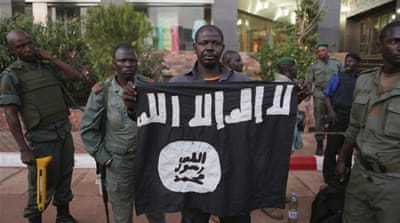 Malian security officials show a flag they said belonged to the attackers [Reuters]