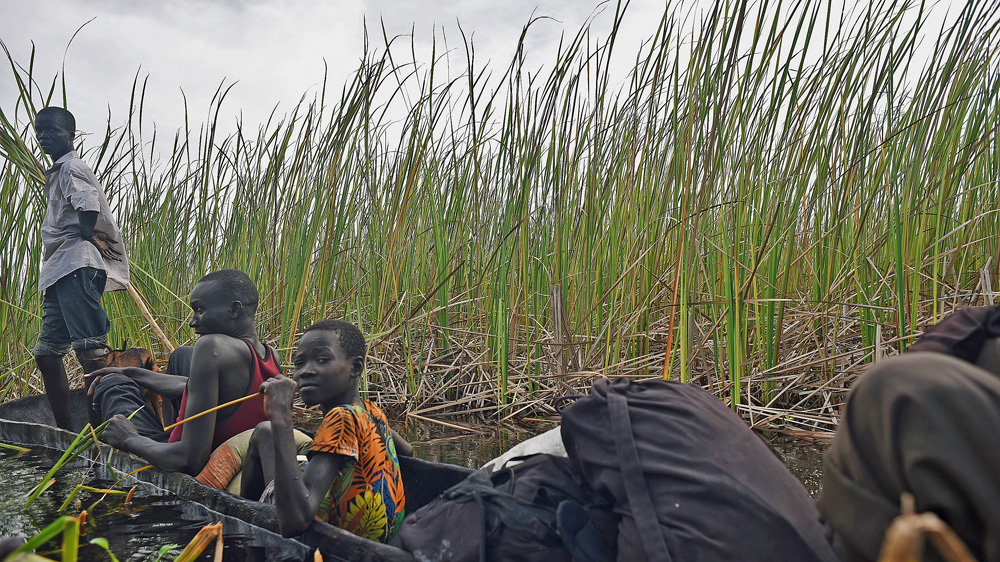 Civilians fleeing by canoe from Leer county towards Kak island [Jason Patinkin/Al Jazeera]