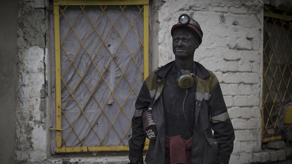 Twenty-year-old Vasily was reluctant to let a stranger photograph him. Then one night, after a few beers, he eventually agreed. He was surprised when we turned up at the legal mine where he works in Viktoria, near Shakhtiorsk, the next day. But, as one of his friends explained to us, among Russian men, 'if you say, you must do - otherwise you're not a real man'. [Janos Chiala and Tali Mayer/Al Jazeera]  