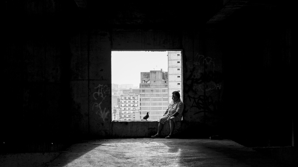 Luis watches the sun set from the tower as he contemplates leaving [Alejandro Cegarra/Al Jazeera] 