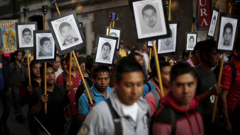 Demonstrators take part in a march to mark the 15-month anniversary of the disappearance of students from Ayotzinapa College Raul Isidro Burgos, in Mexico City
