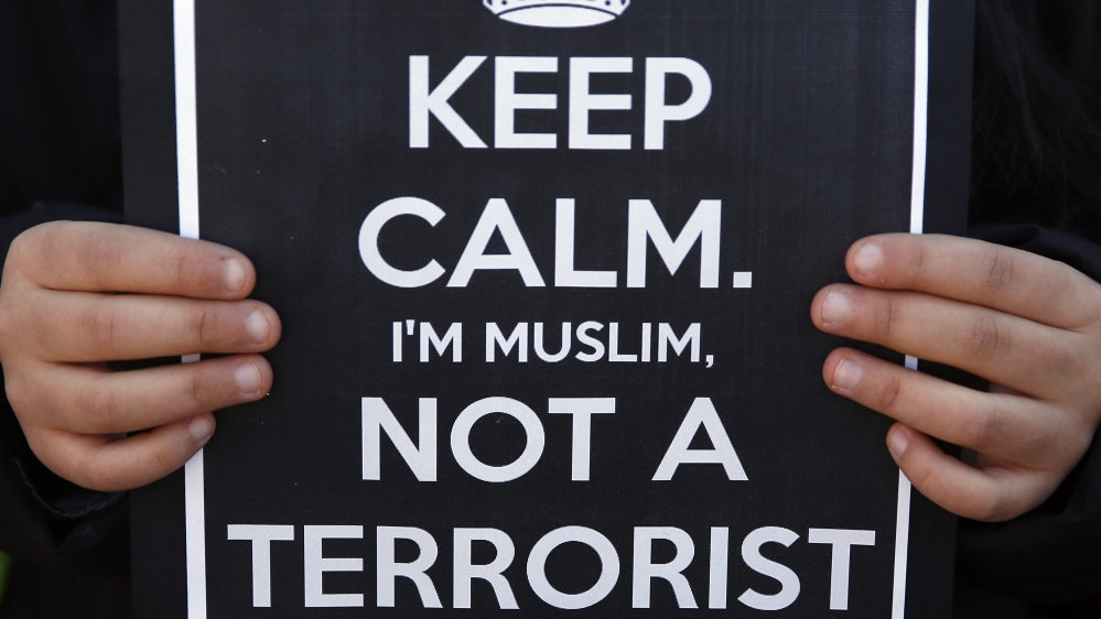 Girl holds a sign during a rally by members of the Muslim community of Madrid outside Madrid''s Atocha train station