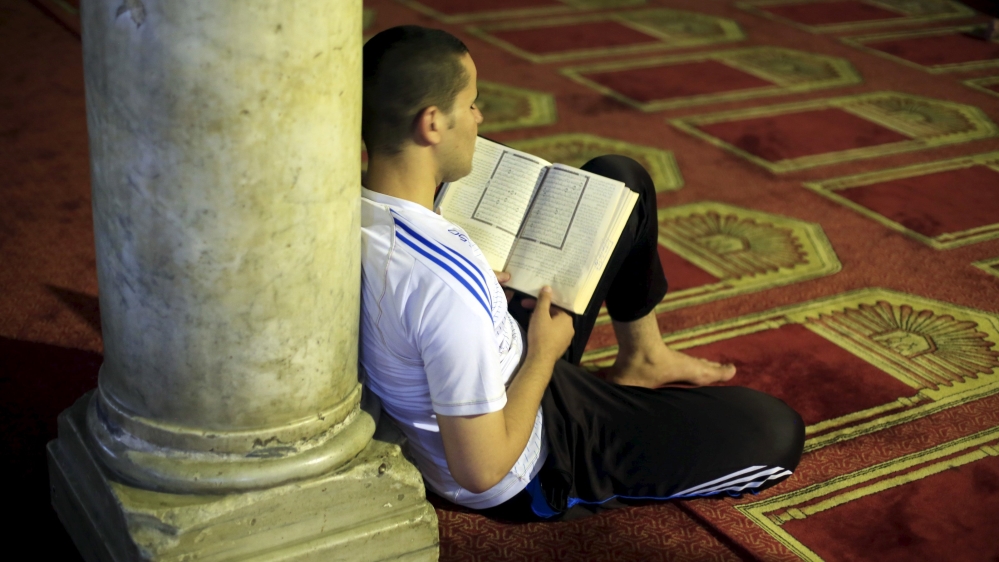 Man reads the Koran after breaking his fast during the holy month of Ramadan at Al-Azhar Mosque in the old Islamic area of Cairo, Egypt