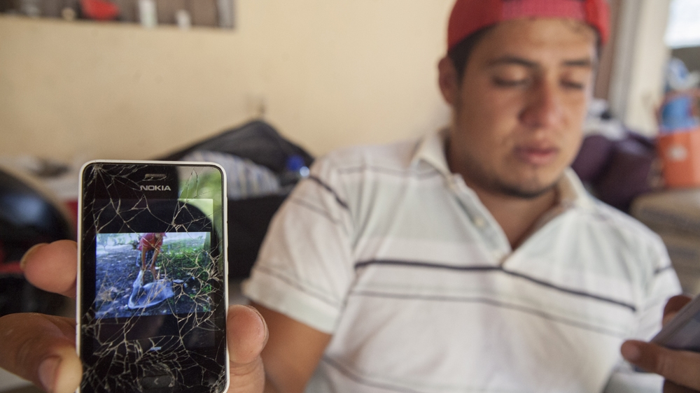 Martin shows a picture of his brother Jonas playing with a donkey [Eduardo Miranda/Al Jazeera]