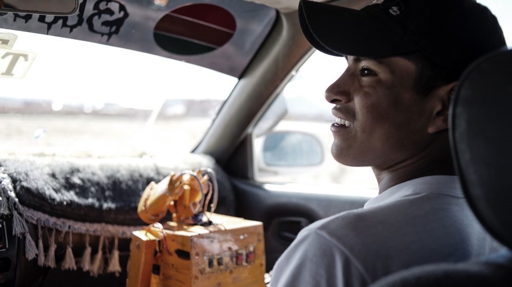 Quispe and Wall-E. Since participating in a high school robotics competition last year he has become something of a local celebrity in Patacamaya [Valentino Bellini/Al Jazeera] 