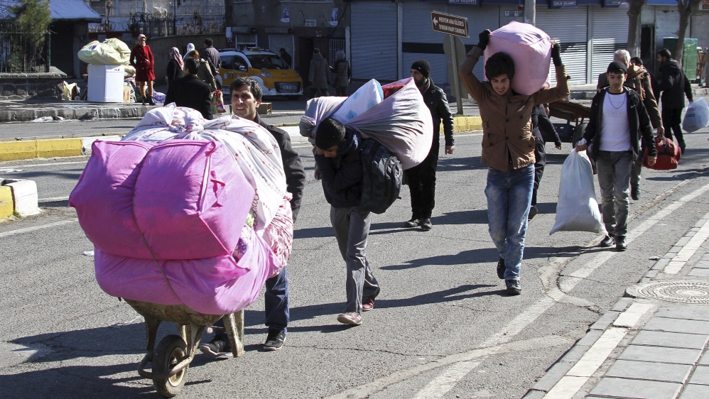 Residents carry their belongings as they flee from Sur district, which is partially under curfew, in the Kurdish-dominated southeastern city of Diyarbakir, Turkey