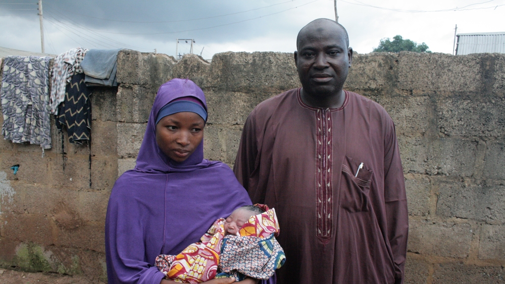 Safara'u Haruna, a 22-year-old mother of four from Kabusa, cradles her baby born only 20 minutes before. Her husband Abdullahi is beside her [Caelainn Hogan/Al Jazeera]