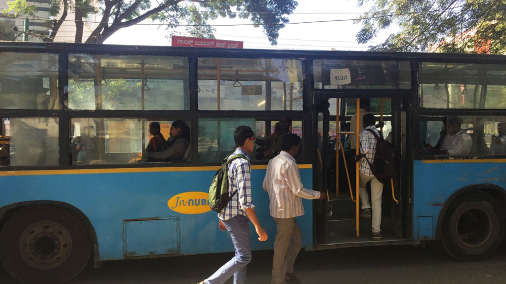 Passengers board the BMTC bus, which is the only public transport system available for the general public [Prathap Nair/Al Jazeera]