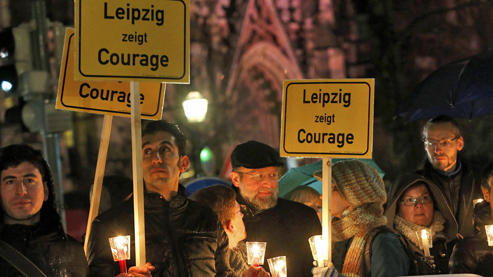 Participants hold candles and posters reading 'Lepizig shows courage' during a protest against LEGIDA [Fabrizio Bensch/Reuters]

