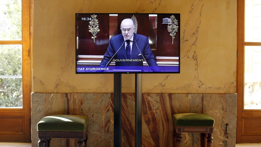 French Interior Minister Bernard Cazeneuve is seen on a screen as he speaks during a debate to extend a state of emergency in France at the National Assembly in Paris