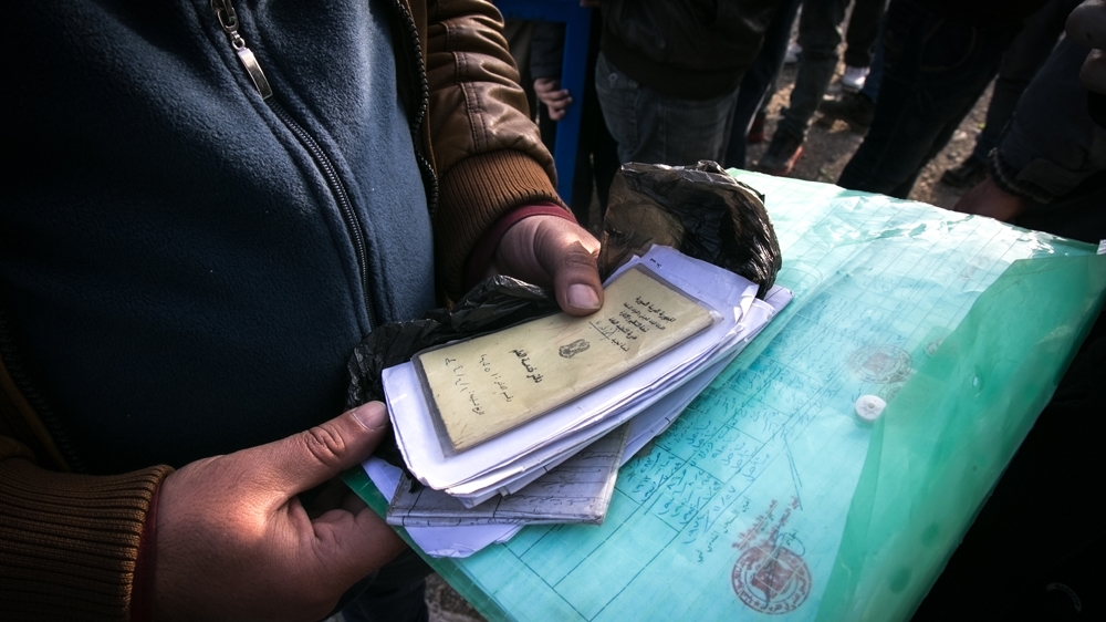 The man portrayed is not allowed to cross the border of Idomeni because he has no passport, despite all the documentation he brought to explain his case [Nicola Zolin/Al Jazeera]