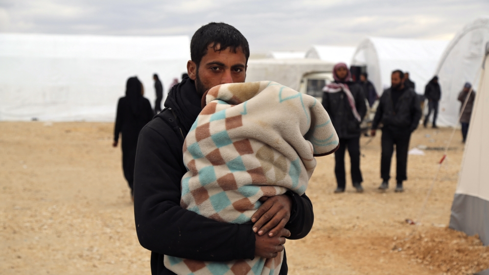 Syrians gather at a temporary refugee camp for displaced Syrians in northern Syria, near Bab al-Salameh border crossing with Turkey